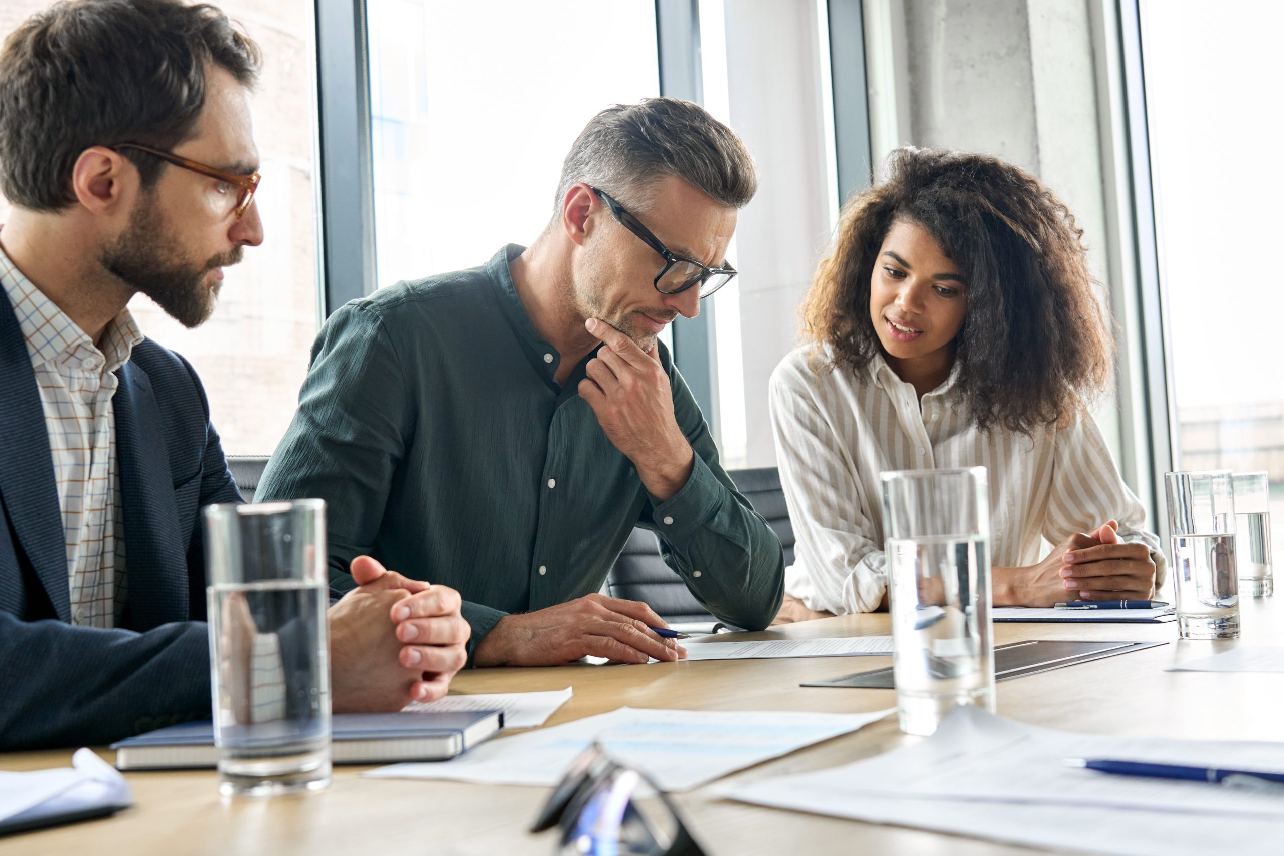 Two men and a woman sitting at a office table