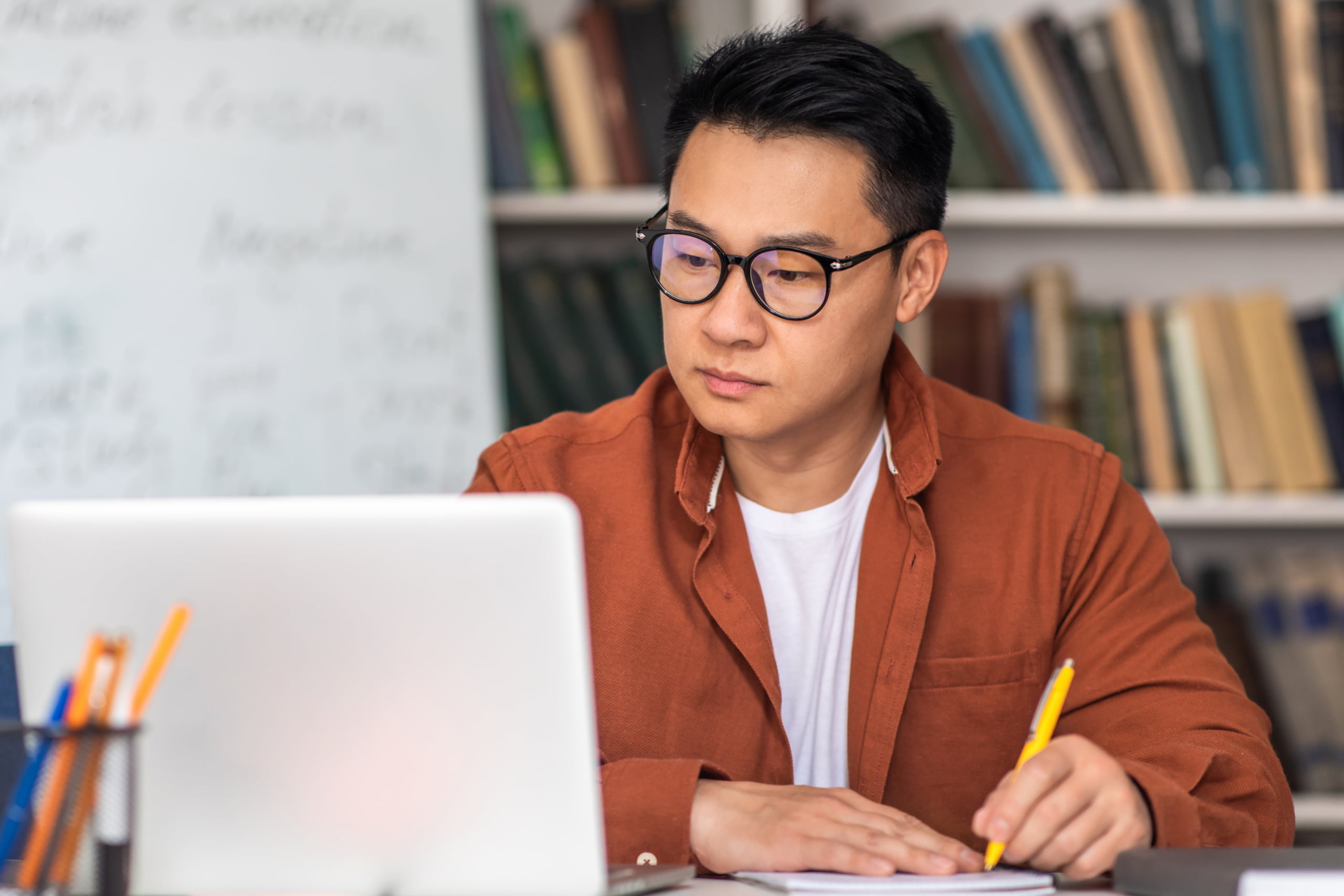 Male teacher looking at laptop