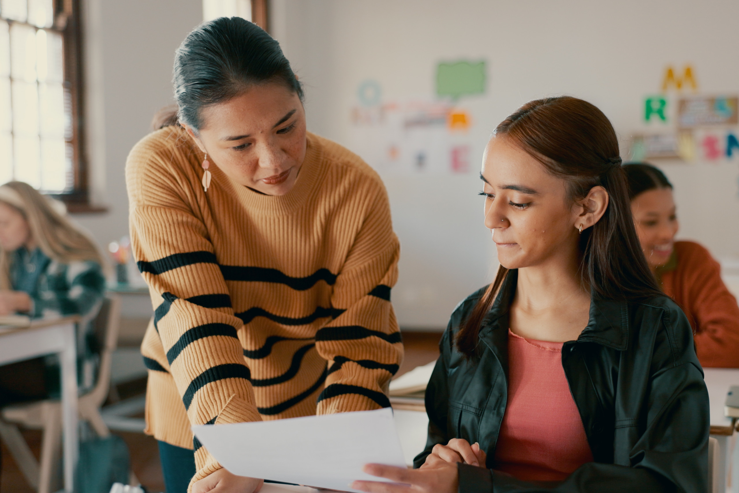 Female teacher talking to female student