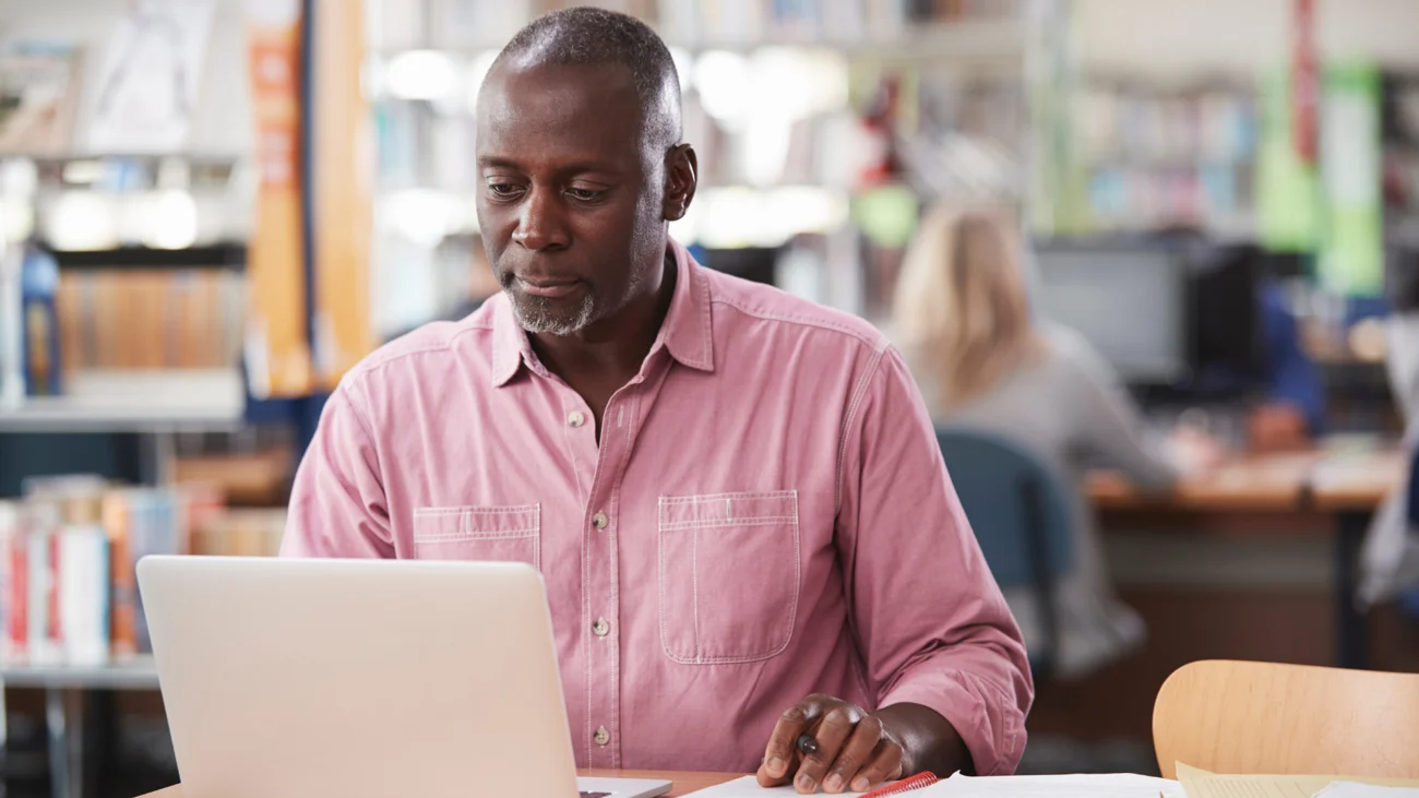 mature-male-student-working-on-laptop-in-college