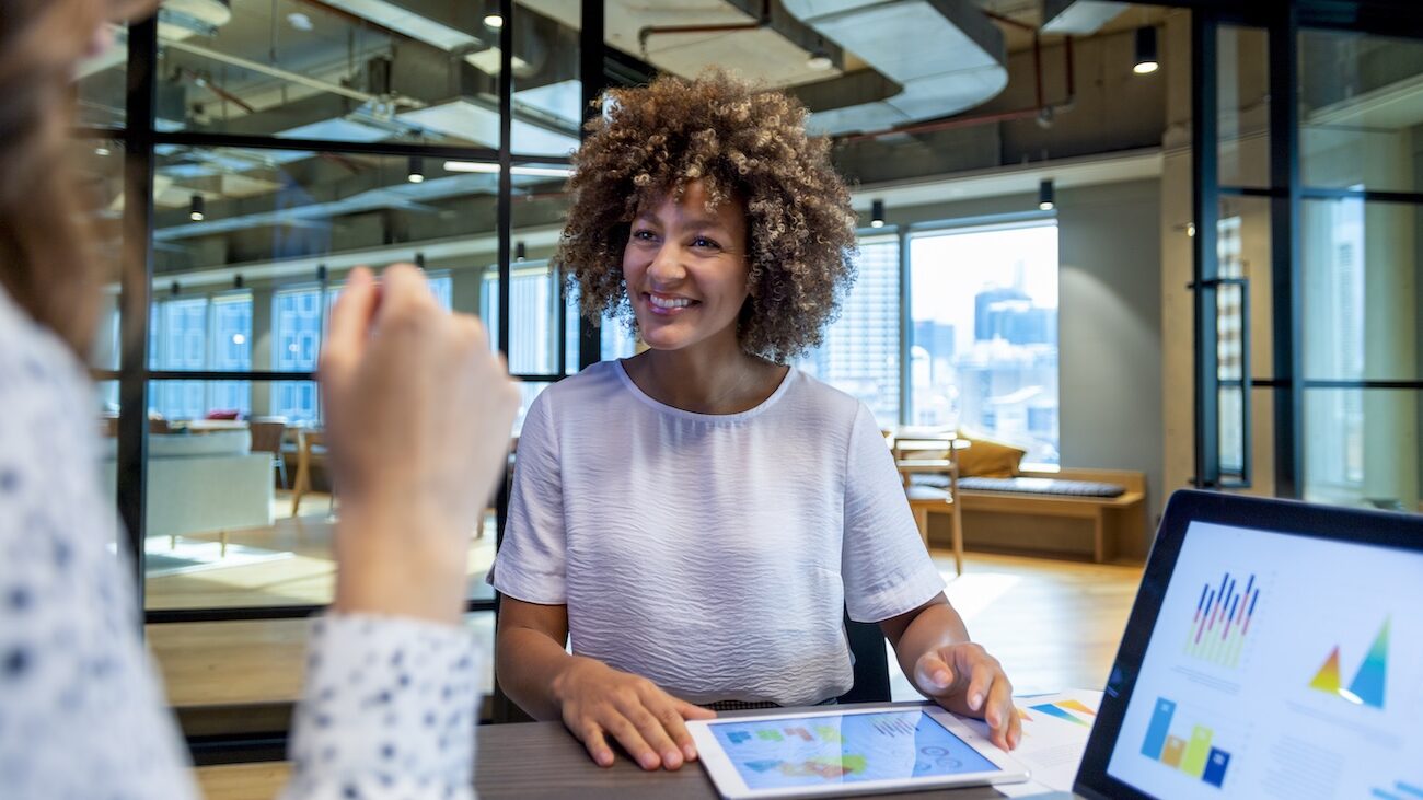 Two women discussing data and reports