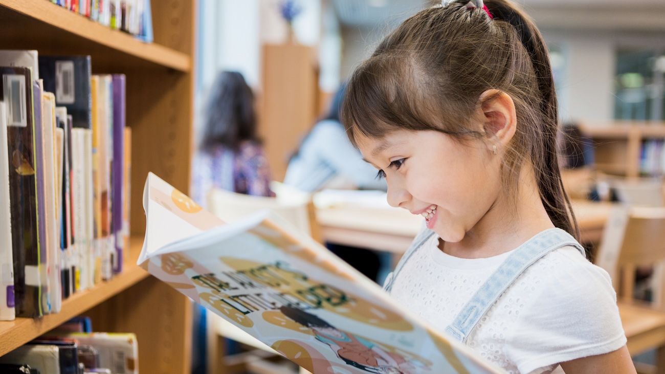 young girl reading in a library